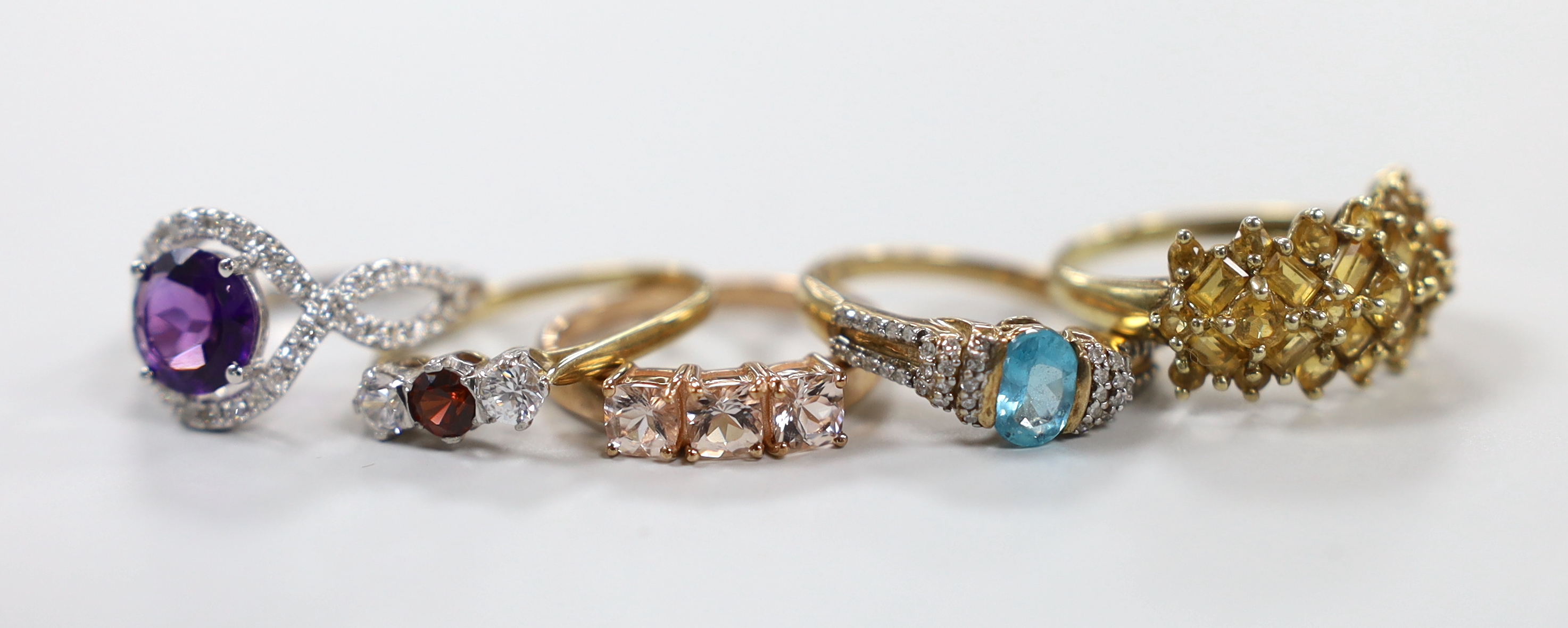 Five assorted modern 9ct gold and gem set rings including a white gold, amethyst and diamond ring, gross weight 12.6 grams.